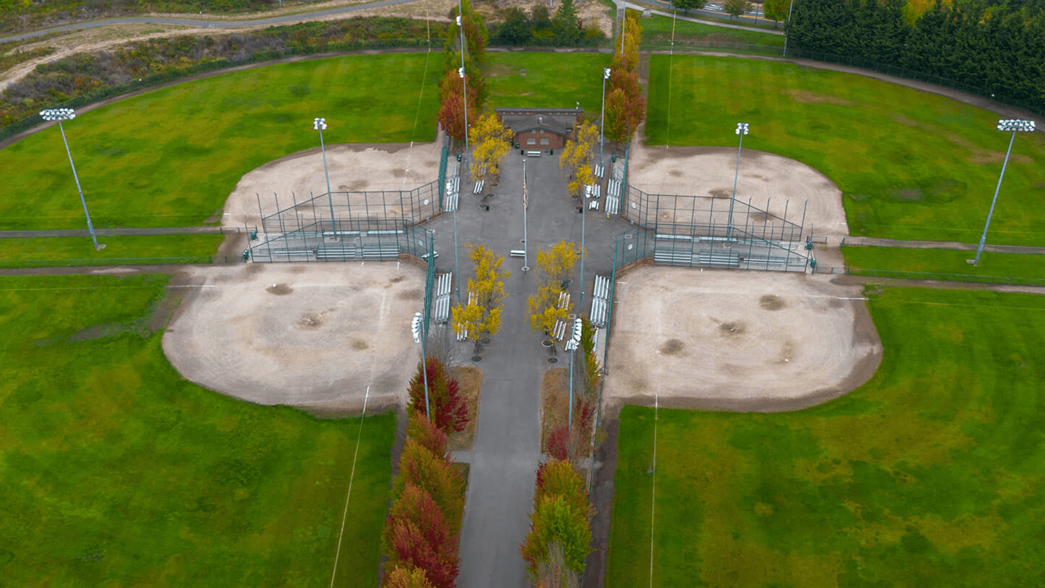 Aerial view of 4 baseball fields and grass.